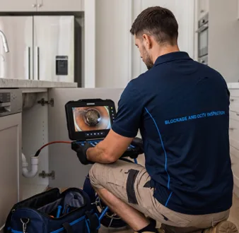 Plumber clearing a blocked toilet in a Maraylya bathroom